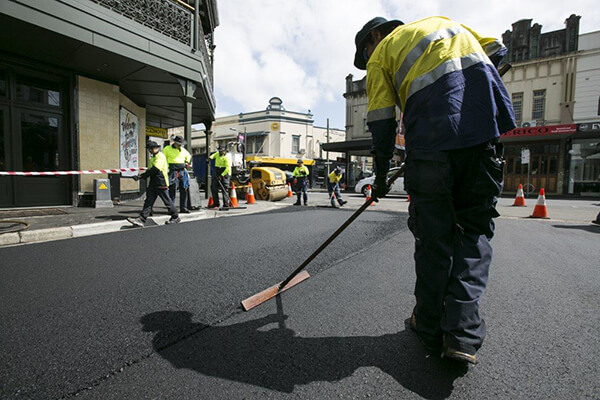 Workers laying Tonerpave on a city street
